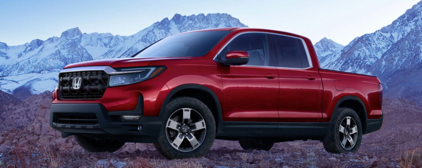 A red 2026 Honda Ridgeline truck parked near a mountain