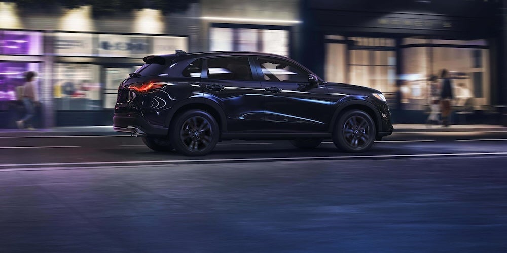 A dark blue 2027 Honda HR-V SUV driving down a city street