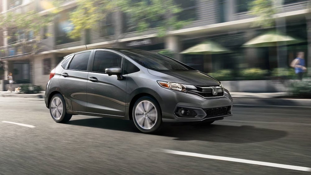 A gray 2019 Honda Fit driving down a city street